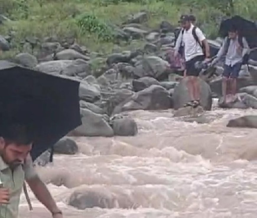 उफनती नदी के साथ खाईनुमा रास्ते से गुजर रहे रेणुकाजी के क्यारी गांव के छात्र